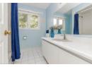 Bathroom featuring light tile patterned flooring, vanity, and a shower with shower curtain