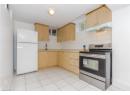 Kitchen featuring stainless steel electric range, freestanding refrigerator, decorative backsplash, light brown cabinets, and under cabinet range hood
