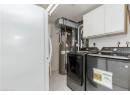 Washroom with light tile patterned floors, washing machine and dryer, and cabinet space