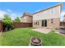 Rear view of house with brick siding, an outdoor fire pit, a fenced backyard, and a patio