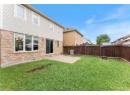 Back of property featuring brick siding, a fenced backyard, and a patio