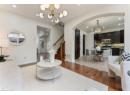 Living room featuring light wood-type flooring, arched walkways, stairway, recessed lighting, and a chandelier