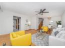 Living room with wood finished floors, stairs, a textured ceiling, a chandelier, and ceiling fan