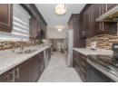 Kitchen with appliances with stainless steel finishes and dark brown cabinets