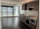 Kitchen featuring appliances with stainless steel finishes, modern cabinets, backsplash, under cabinet range hood, and dark wood finished floors