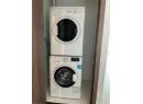 Laundry room with light tile patterned floors and estacked washer and dryer
