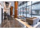 Community lobby with a wall of windows, a city view, a towering ceiling, and recessed lighting