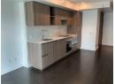 Kitchen with tasteful backsplash, dark wood-style flooring, modern cabinets, and light stone counters