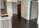 Kitchen with dark wood finished floors, a heating unit, light stone countertops, and modern cabinets